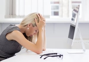 A frustrated woman in front of a computer.
