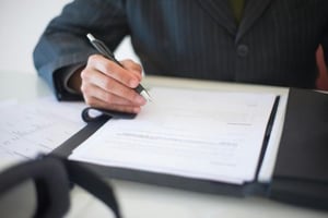 A person writing something down on a list.