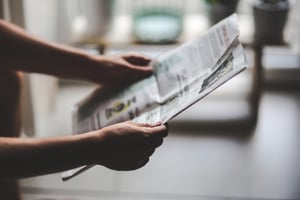 A person holding a newspaper.
