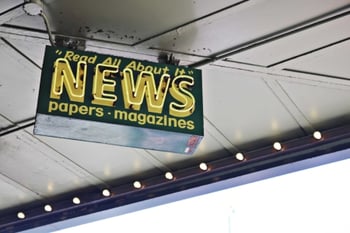 A sign for a news stand.