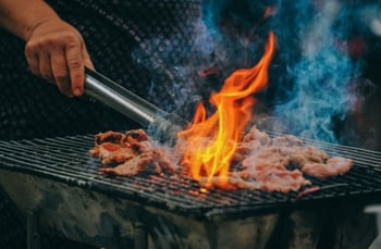 A person cooking meat.