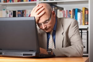 A frustrated businessman in front of a computer.