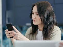 A woman looking at earned media that appeared on owned media.